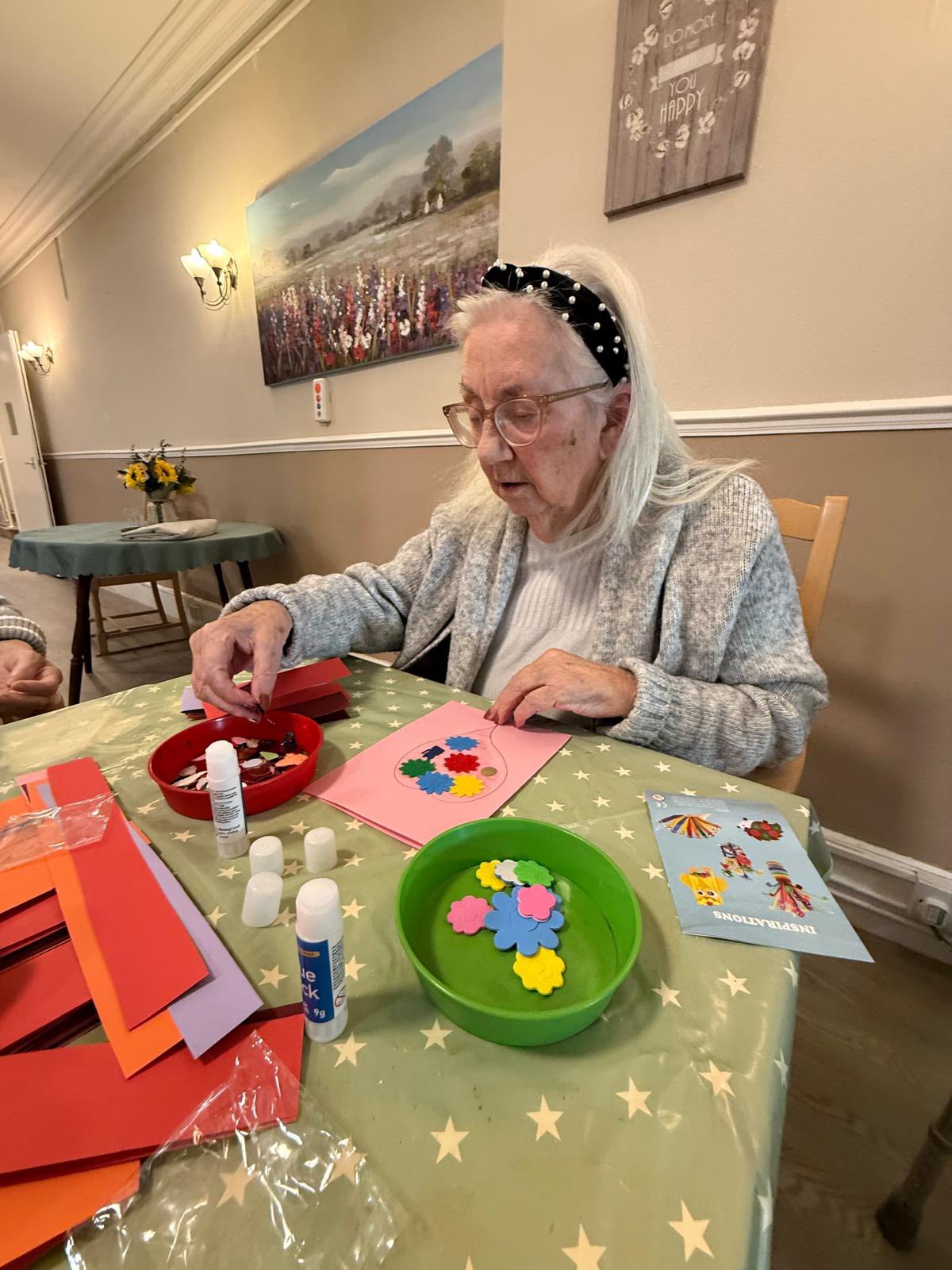 Senior decorating a handmade card with flowers