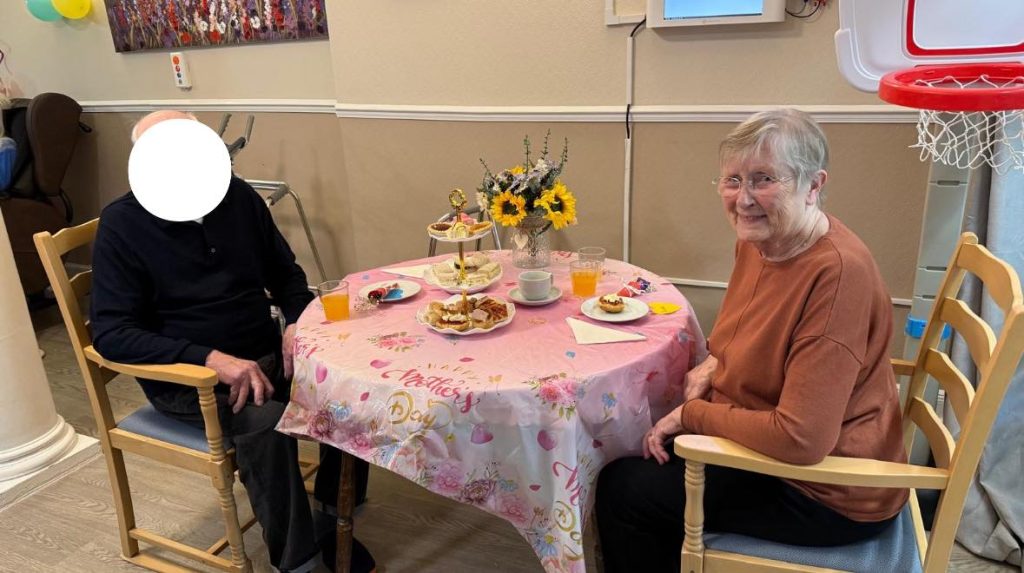Elderly couple seated for a Mother’s Day tea