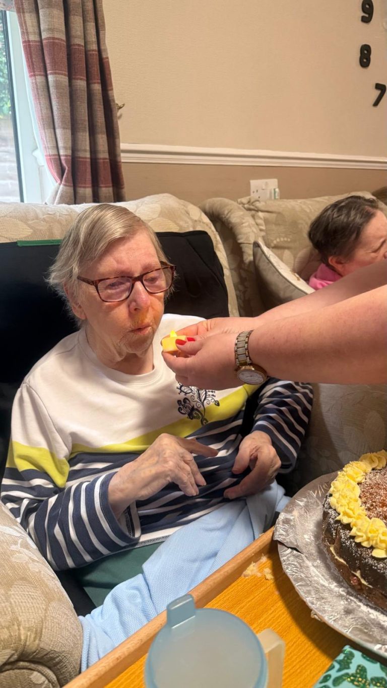 Senior blowing out candle on birthday cake
