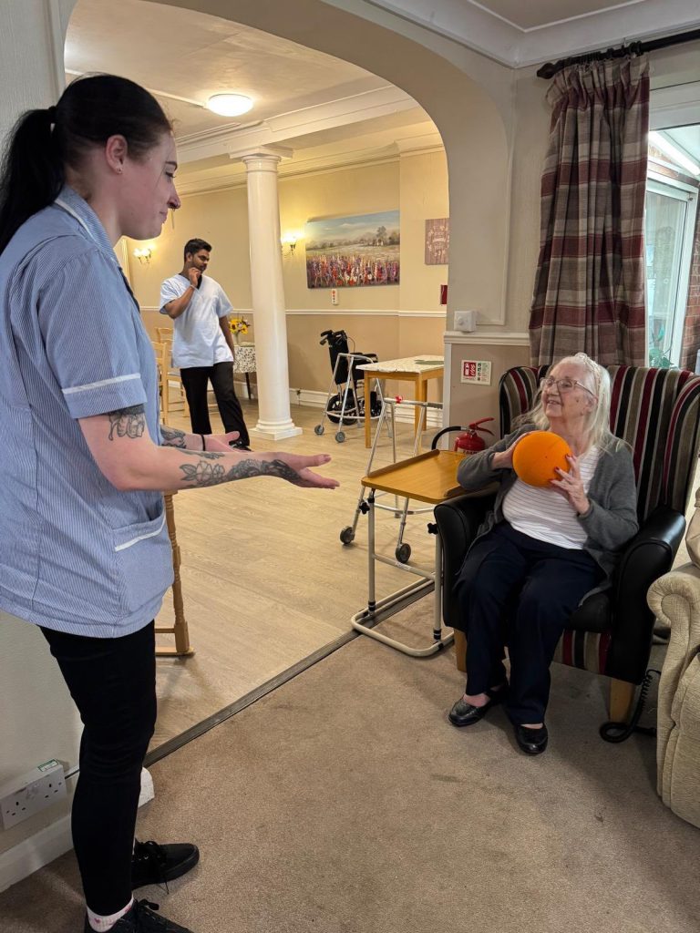 Resident and staff member playing a ball toss game.