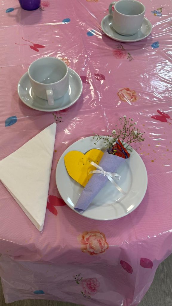 Tea cup setup with small gift and heart card on plate
