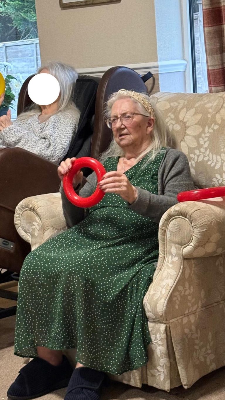 Care home residents doing arm exercises with rings