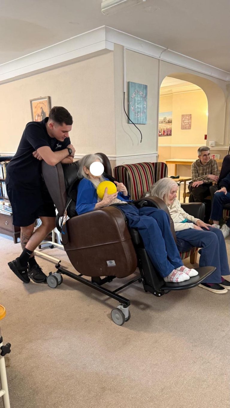 Elderly woman holding a yellow ball during activity.