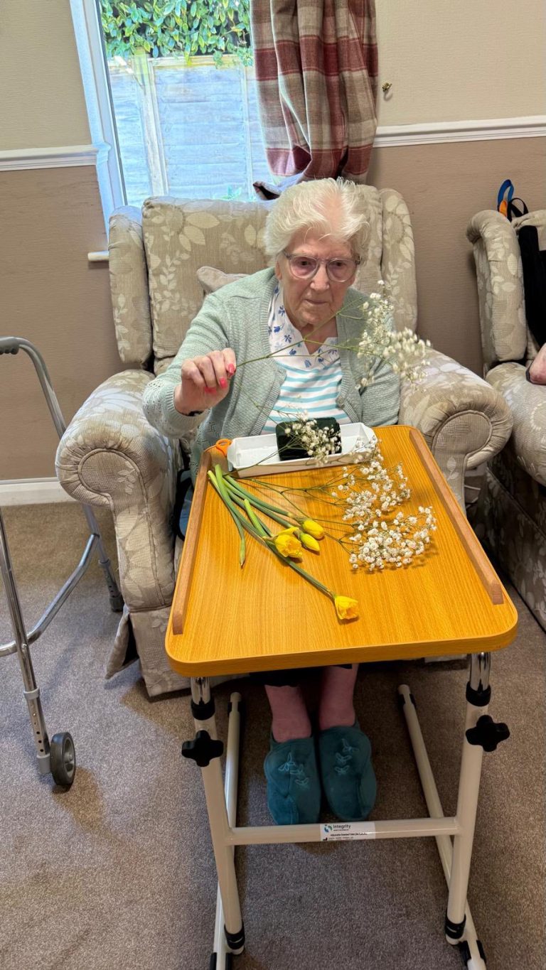 Person organizing flower stems on a table indoors.