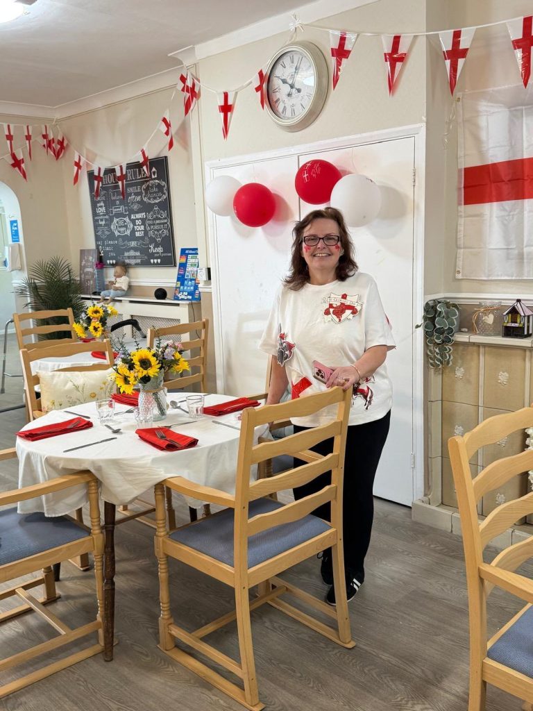 Woman standing by a decorated dining table with England-themed decorations.