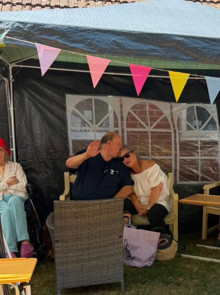 Couple sharing a quiet moment under the garden marquee.