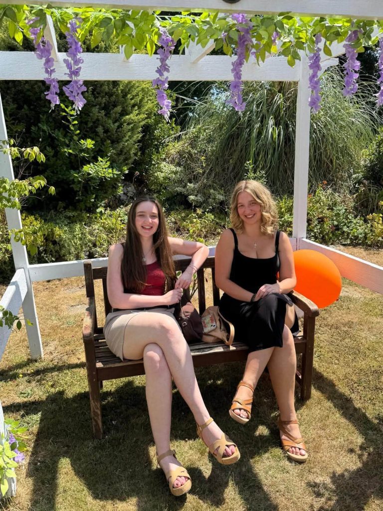 Two visitors relaxing on a garden bench