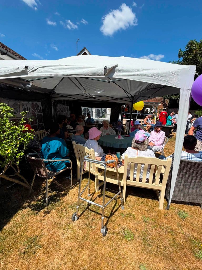 Residents relaxing under a garden gazebo during a summer event at Orchard House Nursing Home.