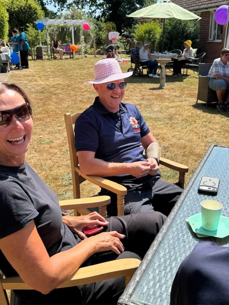 Staff and guests relaxing together at the garden party.