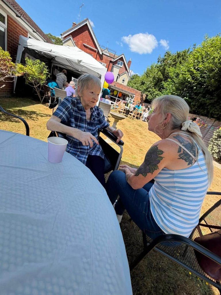 Resident chatting with a visitor in the care home garden.