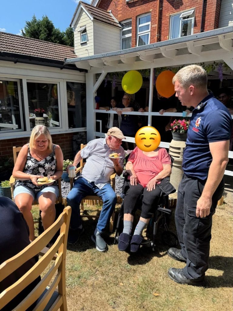Residents and staff socialising at the outdoor summer event.