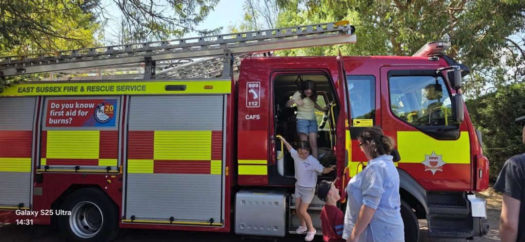 Children climbing out of a fire engine during a community safety event.