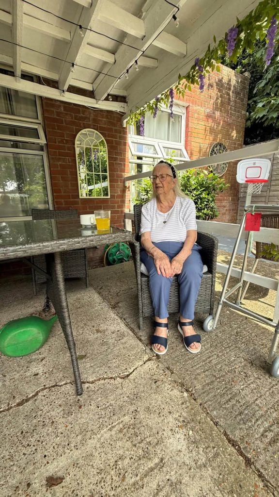 Resident relaxing on the covered patio with a refreshing drink.