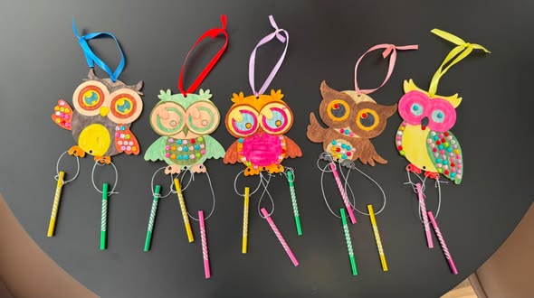 Colourful handmade owl decorations on display.