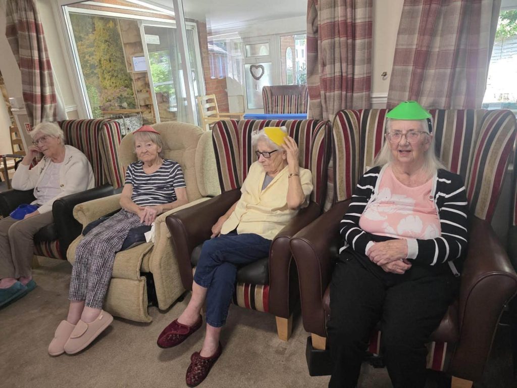 Older woman holds a yellow ball during a group game.