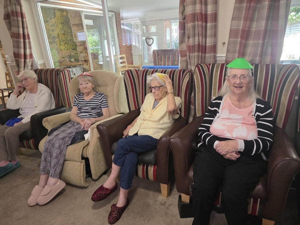 Residents sit in a lounge while participating in a group activity.