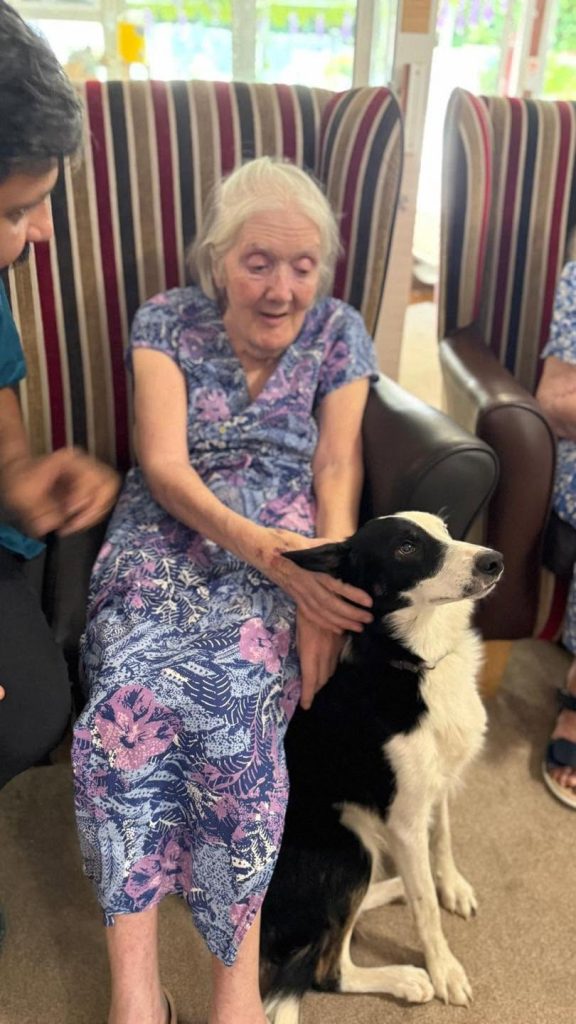 Resident enjoying companionship from a therapy dog