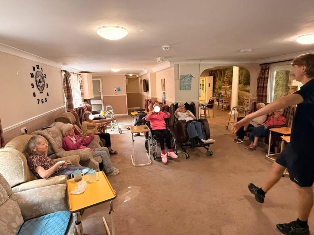Group of elderly residents participating in a seated exercise activity.