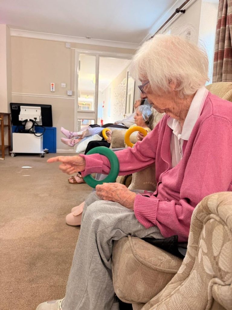 Older residents holding colorful balls during a group activity.