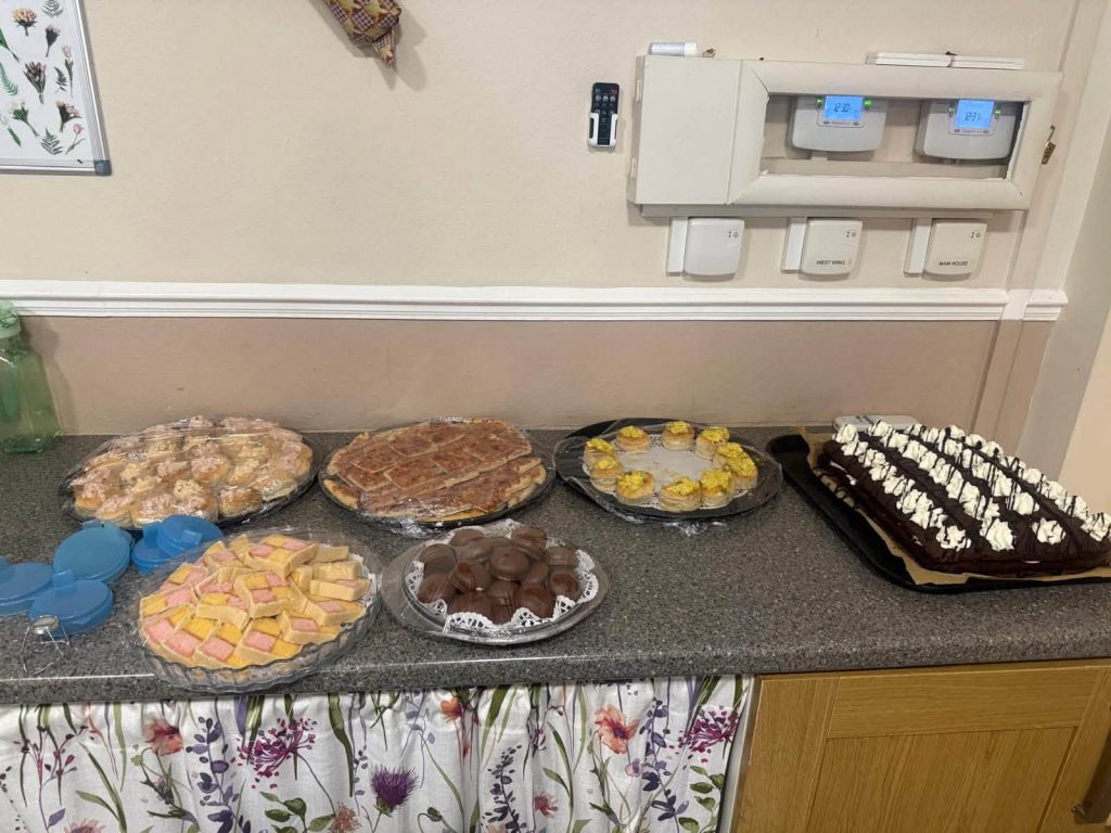 A selection of sweet treats, cakes, biscuits and chocolate desserts prepared for a care home celebration.